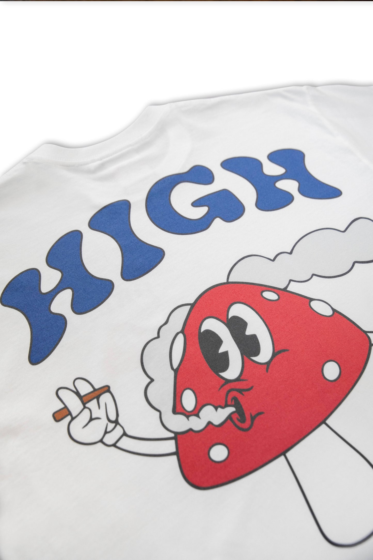 Close-up of High On Life T-Shirt back print showing red mushroom cartoon smoking with bold 'HIGH' text. Durable DTG print on white cotton fabric.