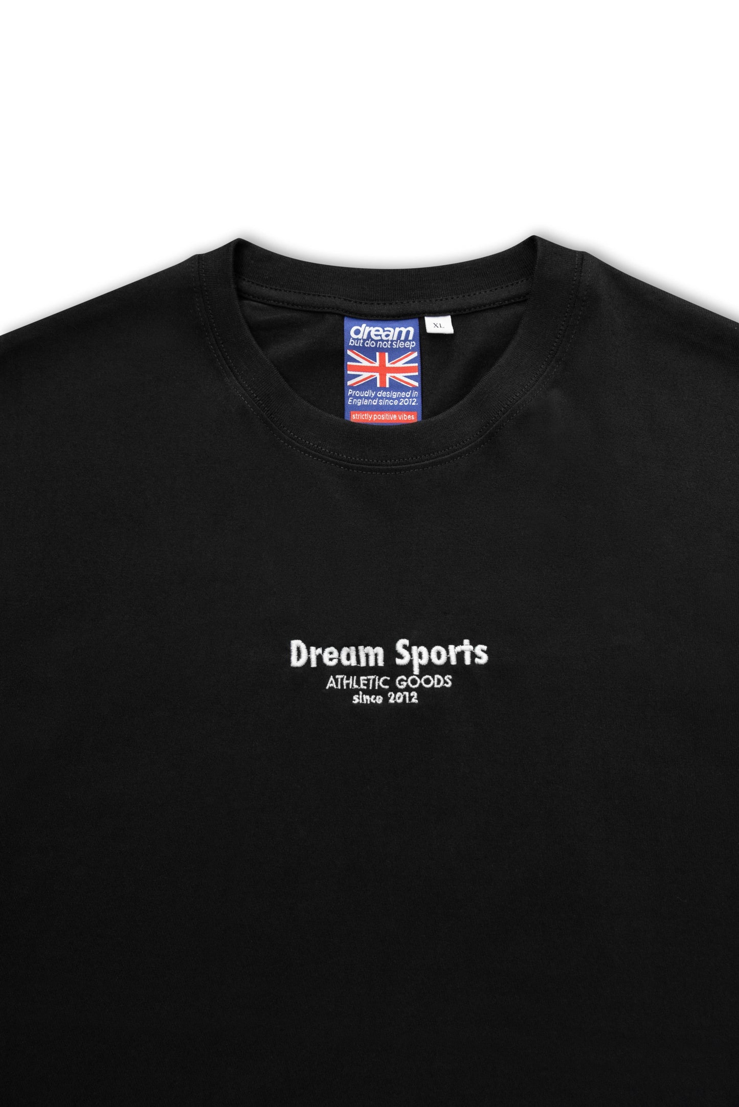 Close-up of black premium short sleeve t-shirt showing 'Dream Sports Athletic Goods' logo embroidery and soft cotton texture.