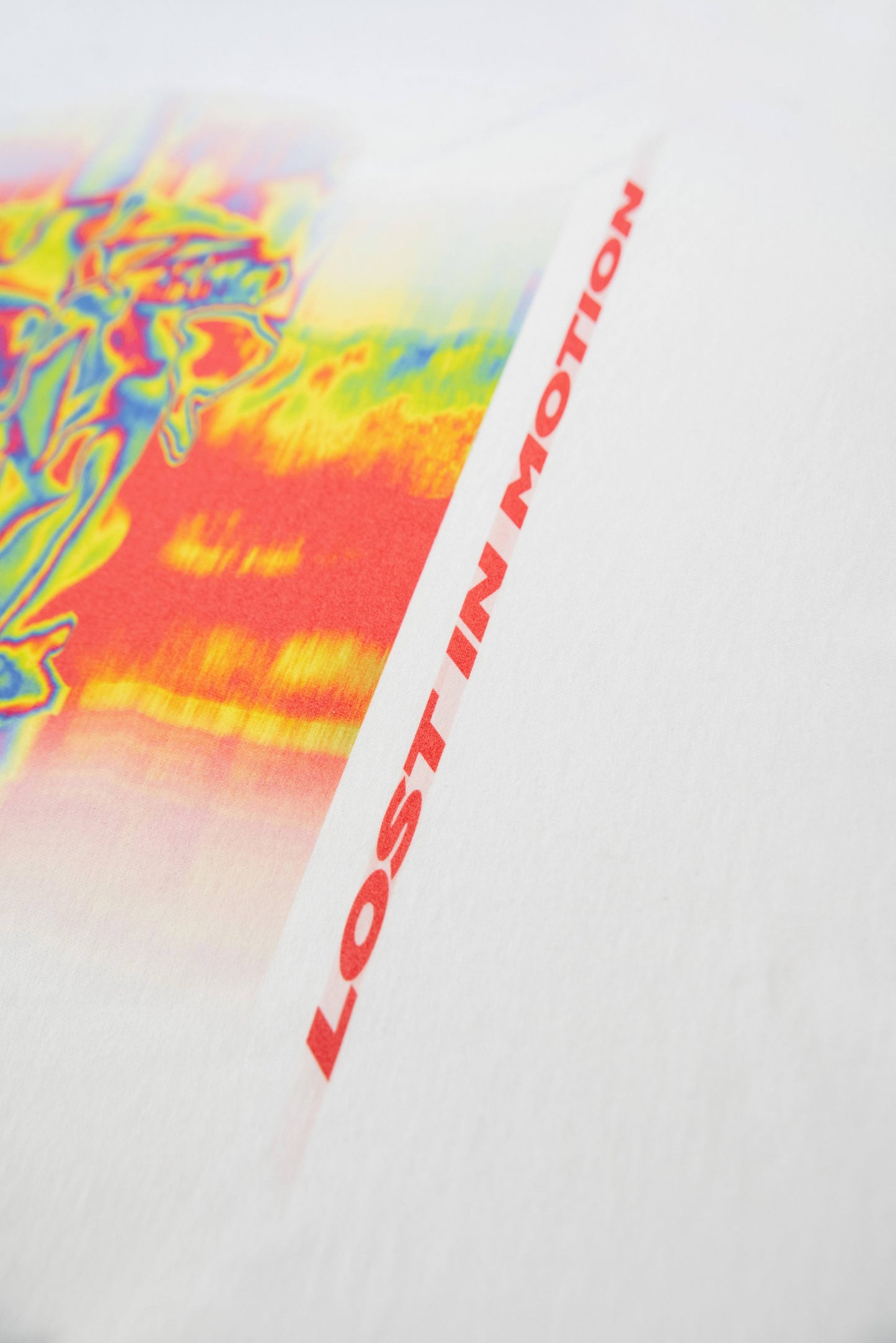 Detail of 'Lost In Motion' red text printed on white cotton T-shirt. Durable DTG print with modern design, part of DBDNS Store's unisex apparel line.