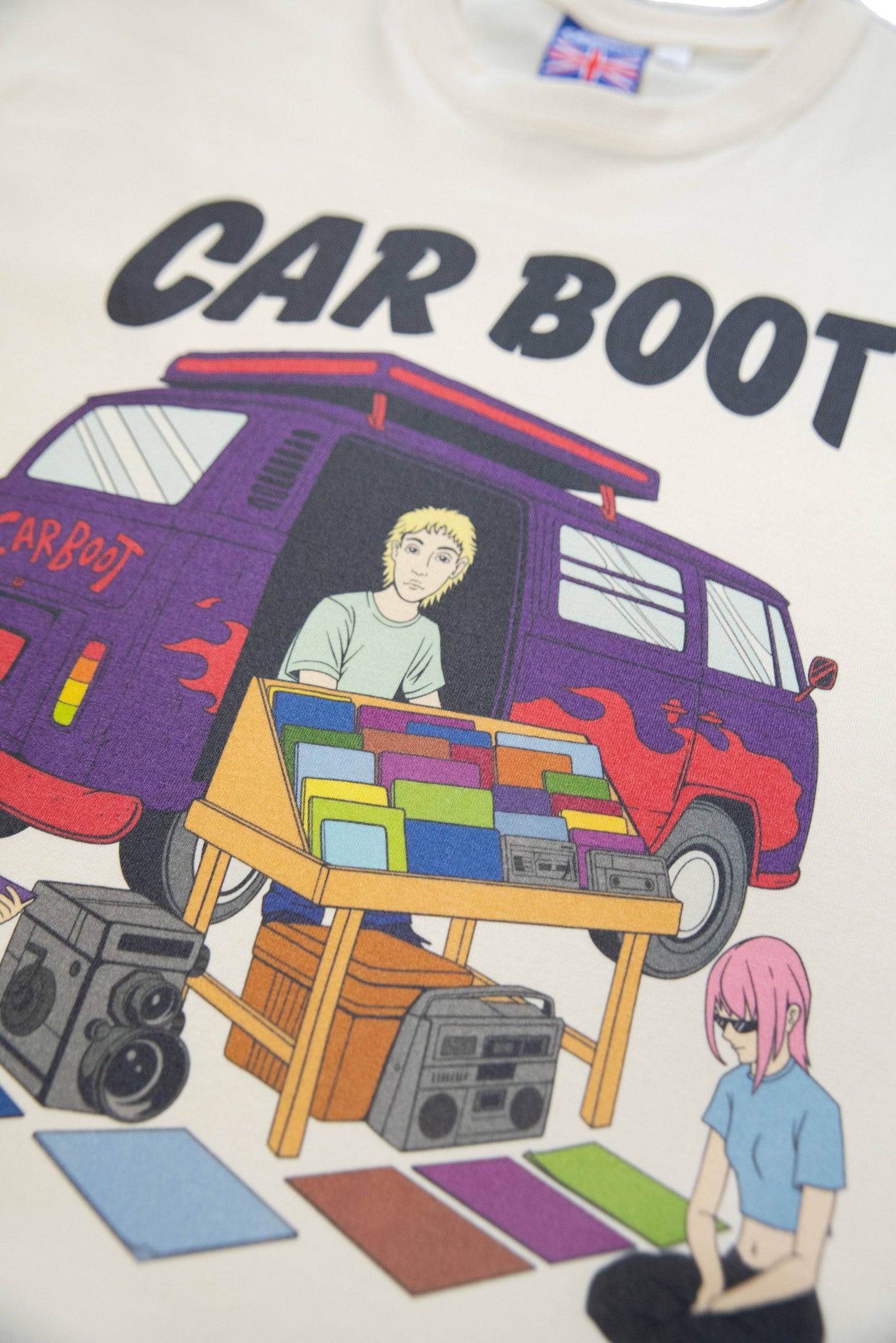 Close-up of Cream T-Shirt - Car Boot Print showing detailed DTG artwork with characters, vinyl records, and retro boomboxes on soft cotton fabric.