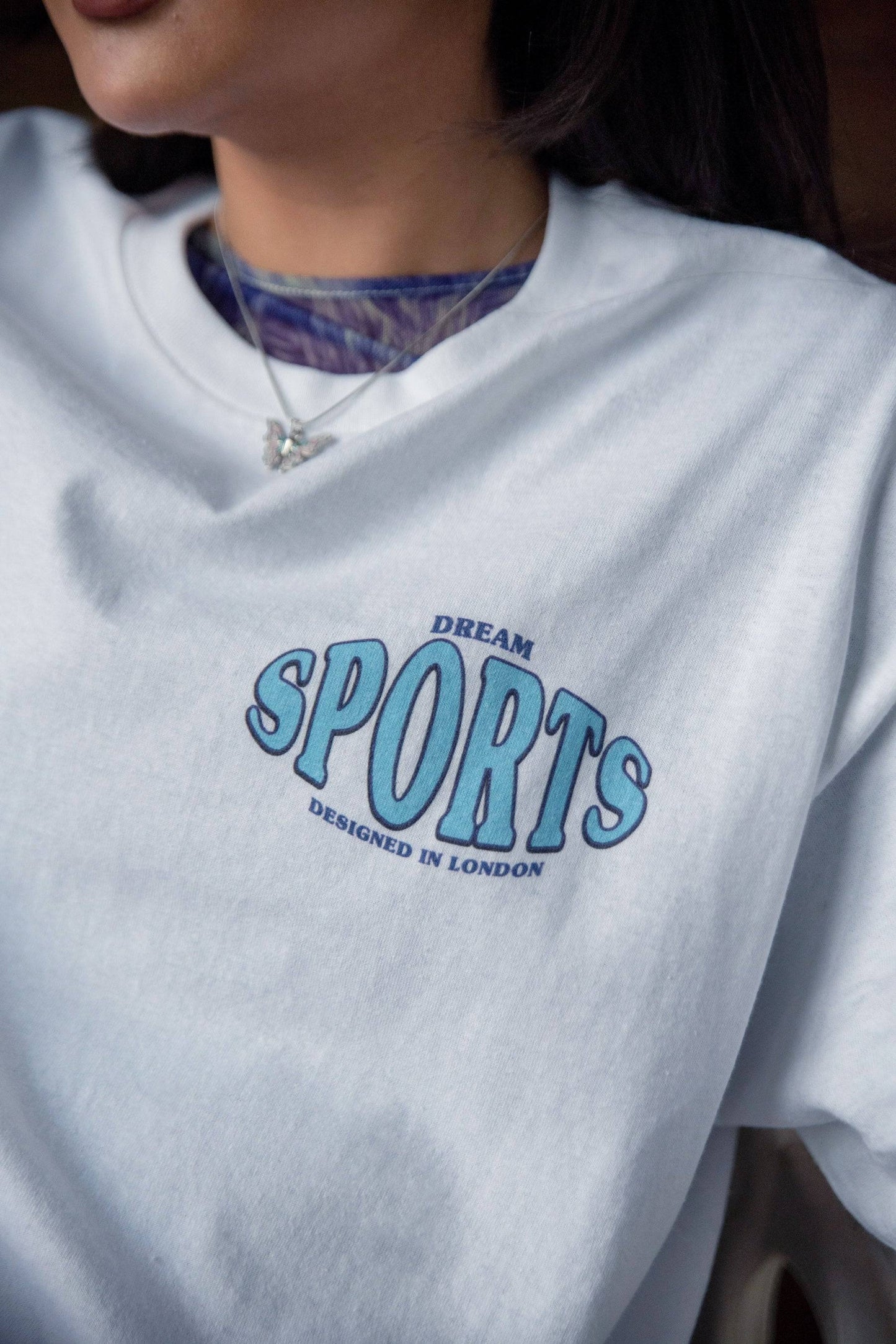 Detailed front view of Dream Sports print on white t-shirt, emphasizing quality cotton fabric and minimalist logo design.