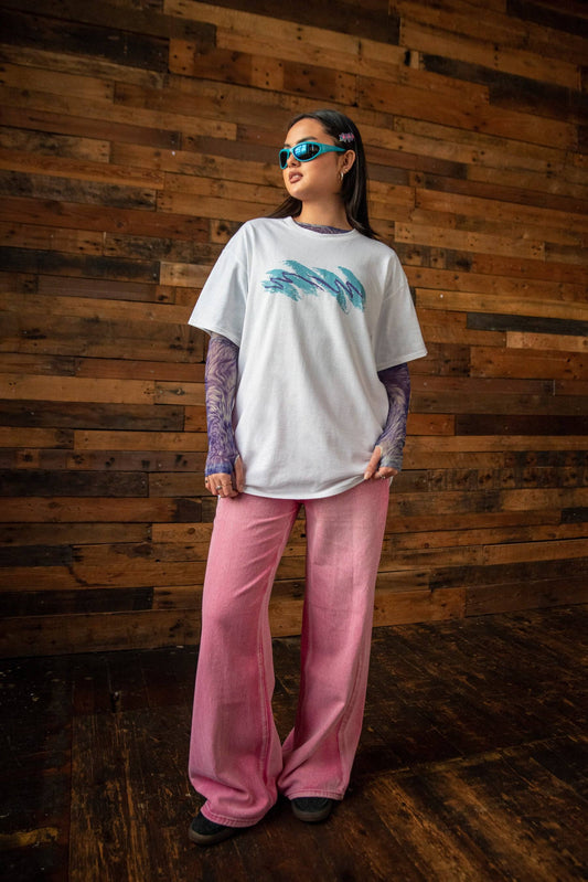 Unisex Jazz Cup White T-shirt featuring bold front graphic, worn with pink pants and layered mesh sleeves. Retro streetwear cotton tee.
