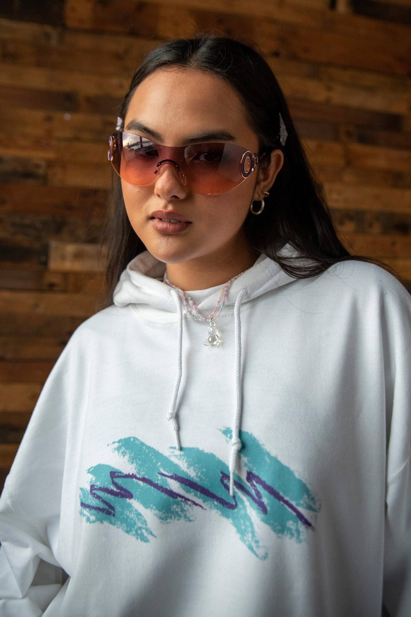 Close-up of Jazz Cup Print Hoodie featuring teal and purple graphic on white cotton. Unisex relaxed fit with drawstring hood detail.