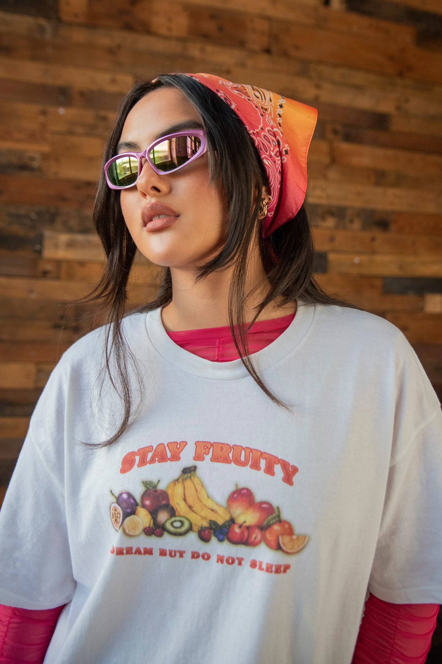 Short Sleeved White Stay Fruity T-shirt styled with pink sunglasses and a red bandana. Features bold fruit graphic and unisex cotton fit.