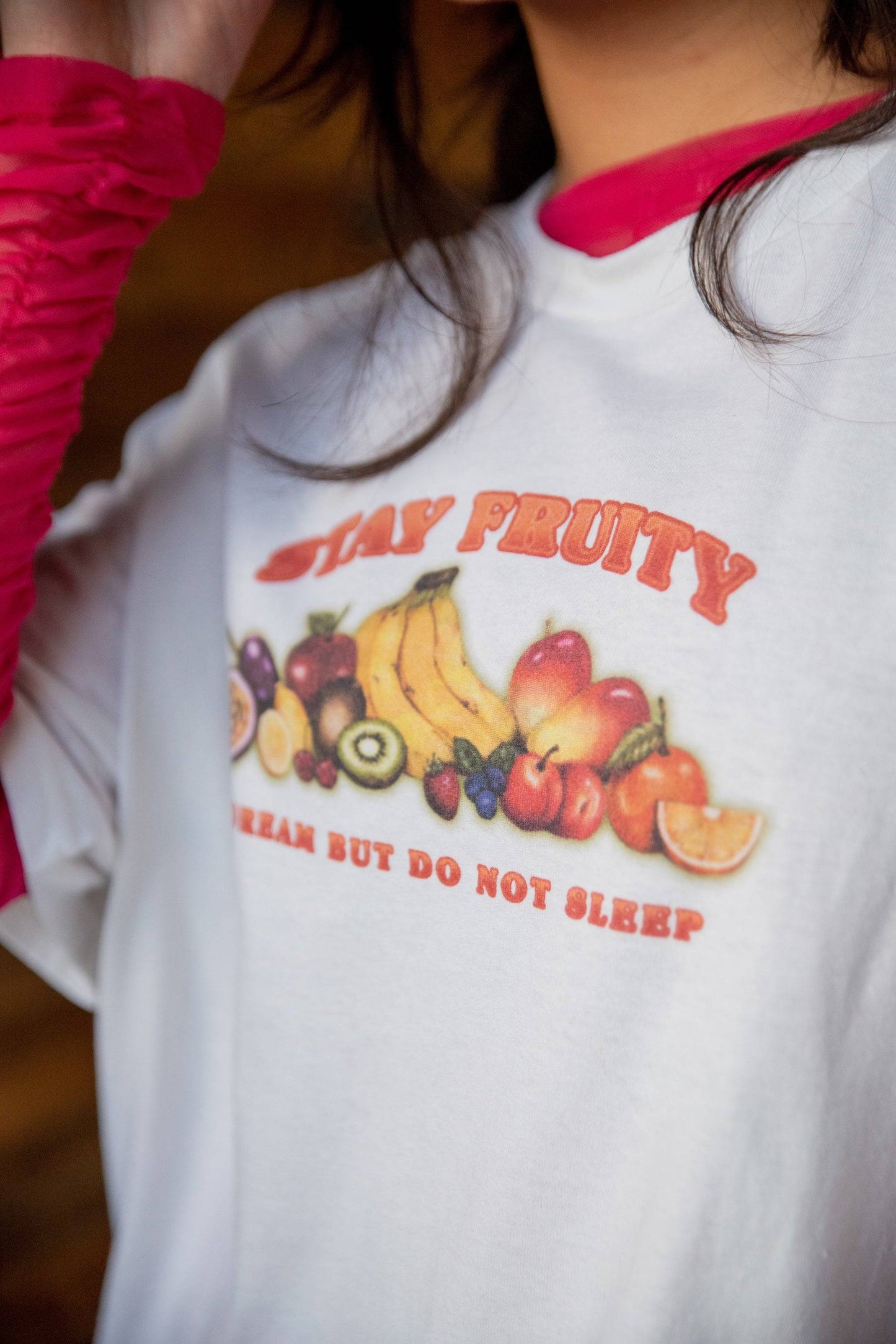 Close-up of Short Sleeved White Stay Fruity T-shirt showing vivid fruit graphic and 'Dream But Do Not Sleep' slogan on soft cotton fabric.