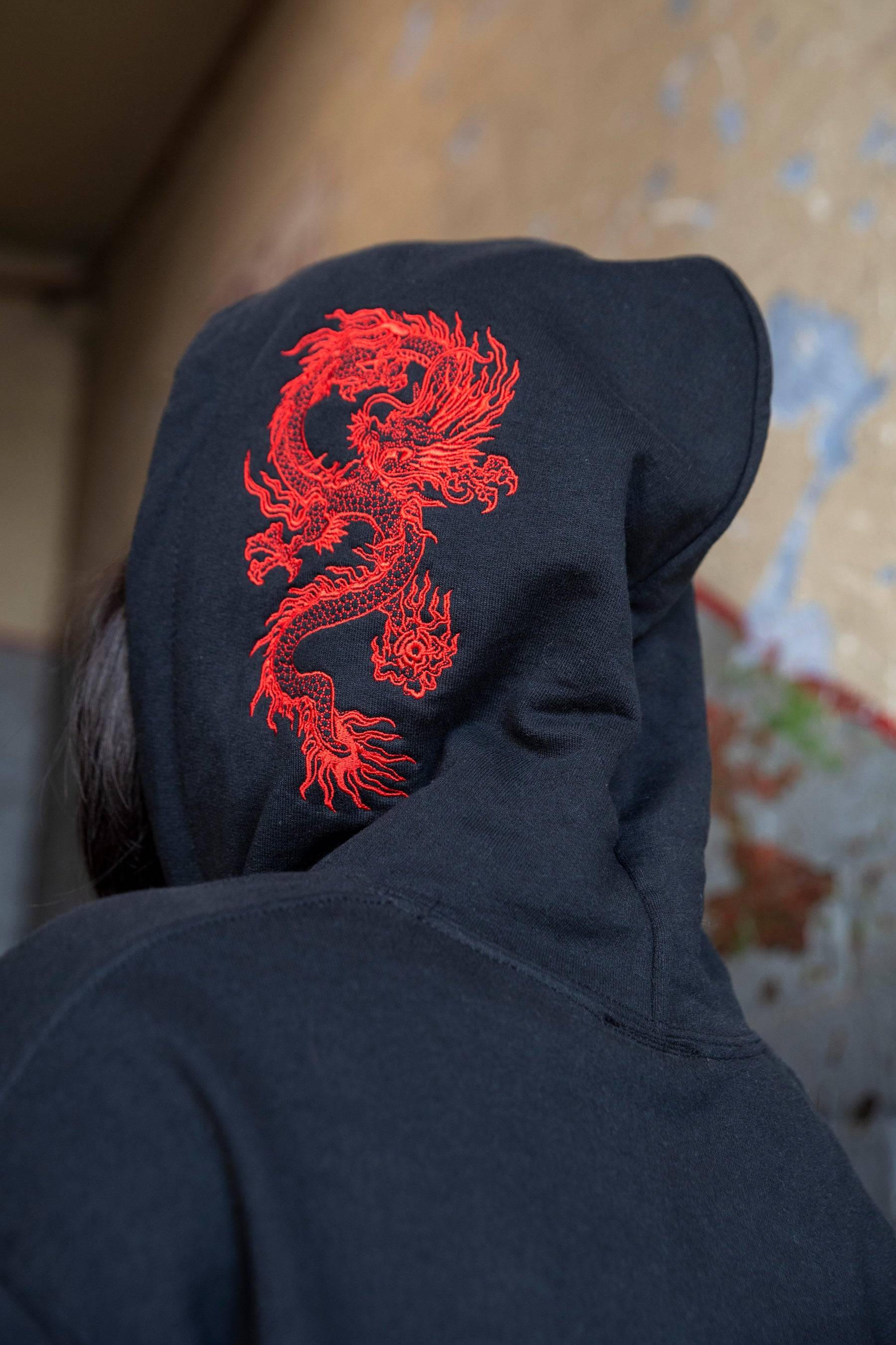Back view of hoodie hood featuring intricate red dragon embroidery, highlighting the bold design of this unisex streetwear piece.