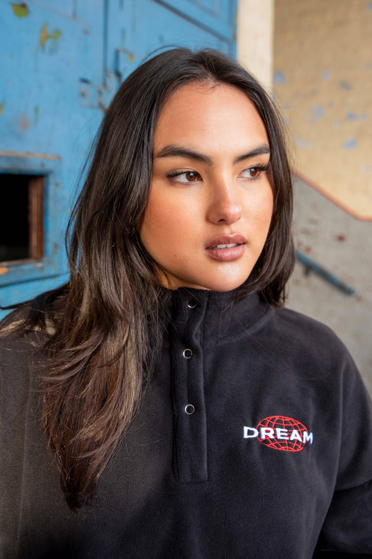 Black Cropped Fleece Hoodie with red globe and white DREAM embroidery, showcasing soft texture and relaxed fit for streetwear appeal.