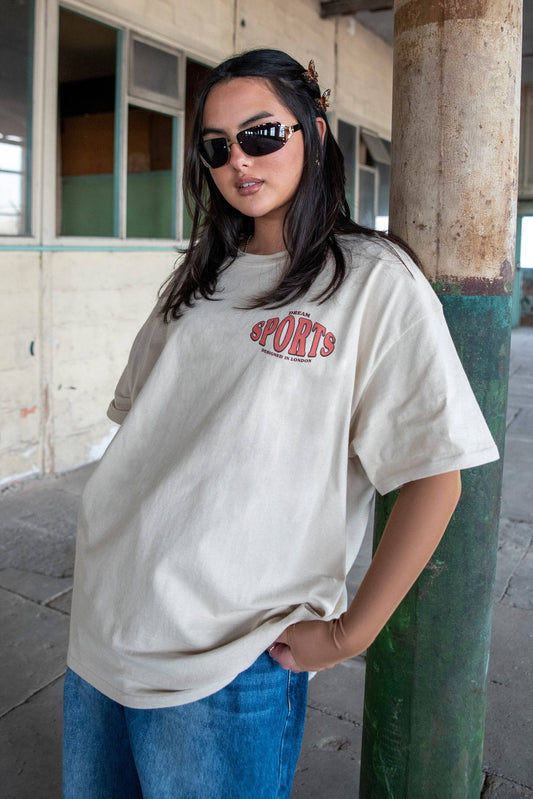 Dream Sports T-Shirt - Designed in London in sand color, styled casually with jeans. Unisex 100% cotton tee from DBDNS Shop.