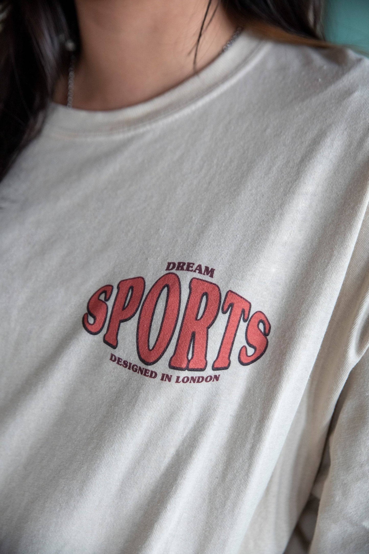 Detailed view of Dream Sports T-Shirt - Designed in London front print in red. Soft sand-colored cotton fabric with relaxed fit.
