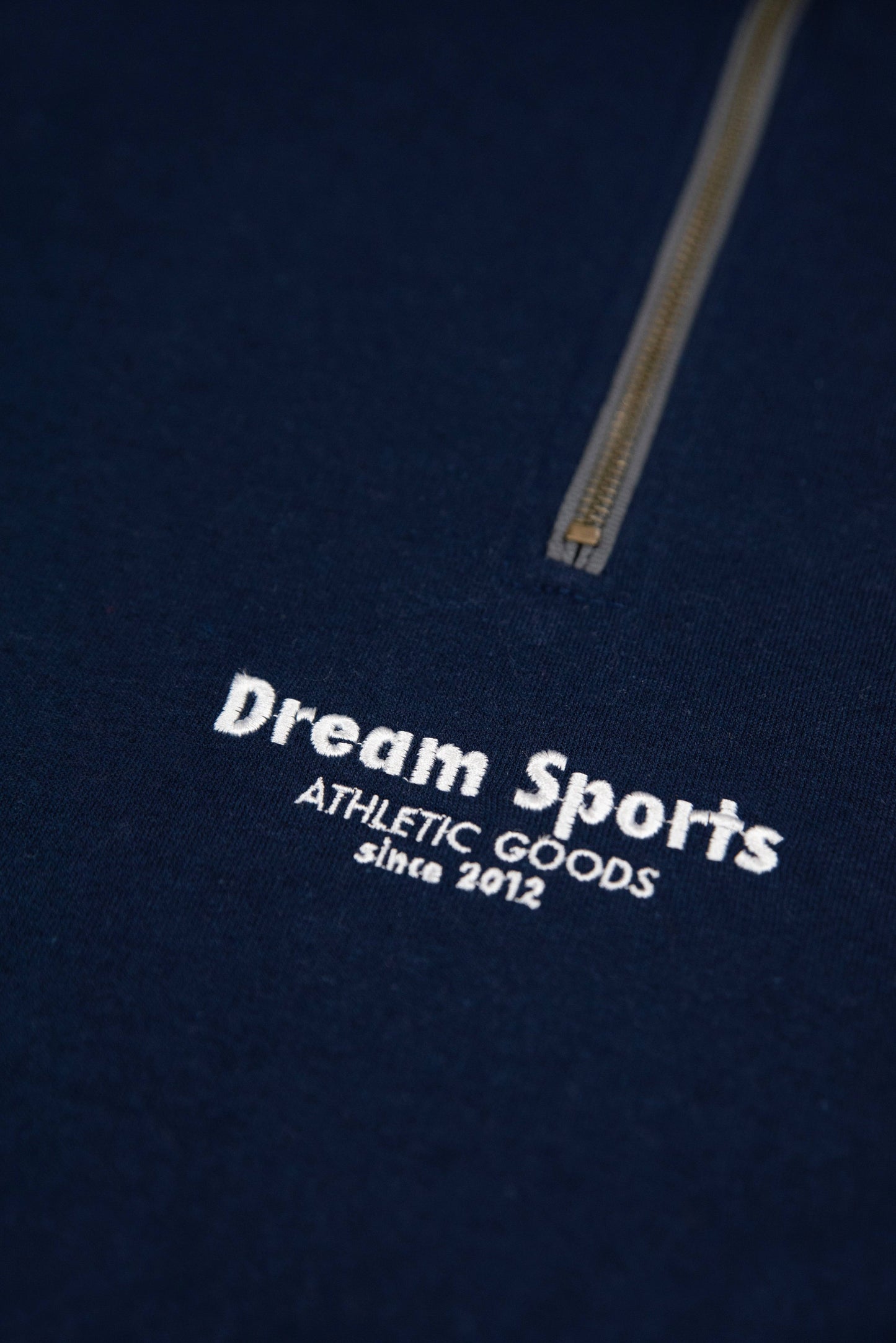 Detailed embroidery of Dream Sports logo on Navy 1/4 Zip Sweatshirt, showcasing premium stitching and zipper design.