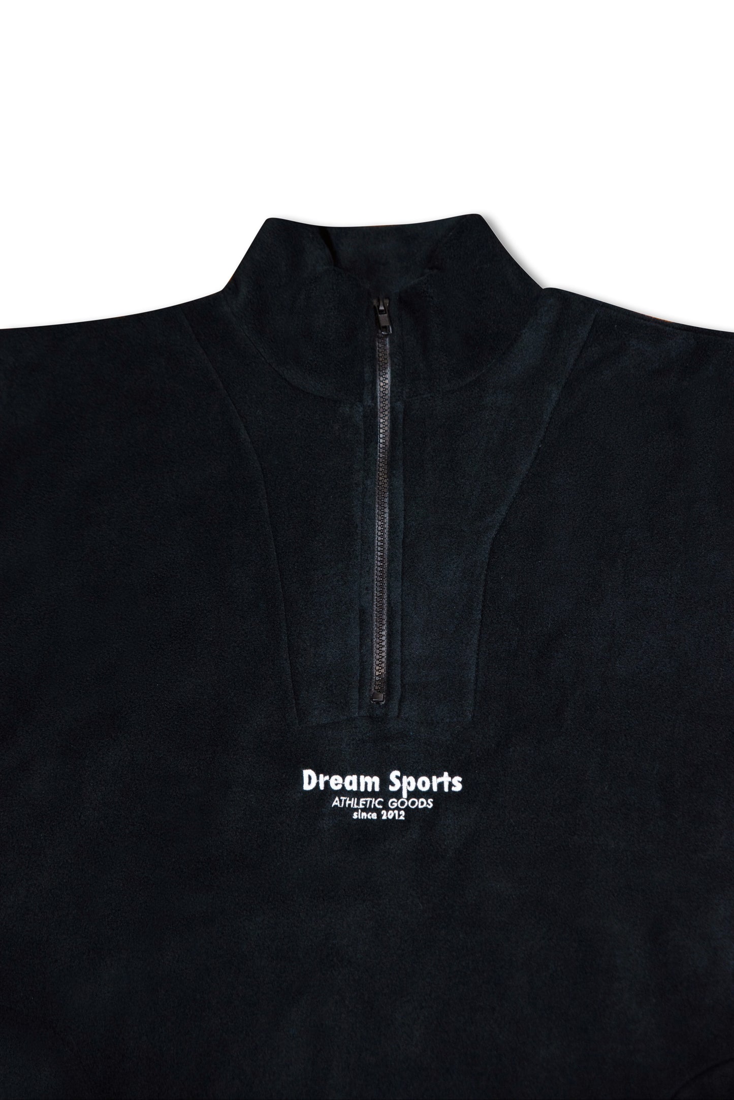 Close-up of black 1/4 zip fleece showing high collar and tonal Dream Sports logo embroidery, highlighting premium fleece texture and stitching.