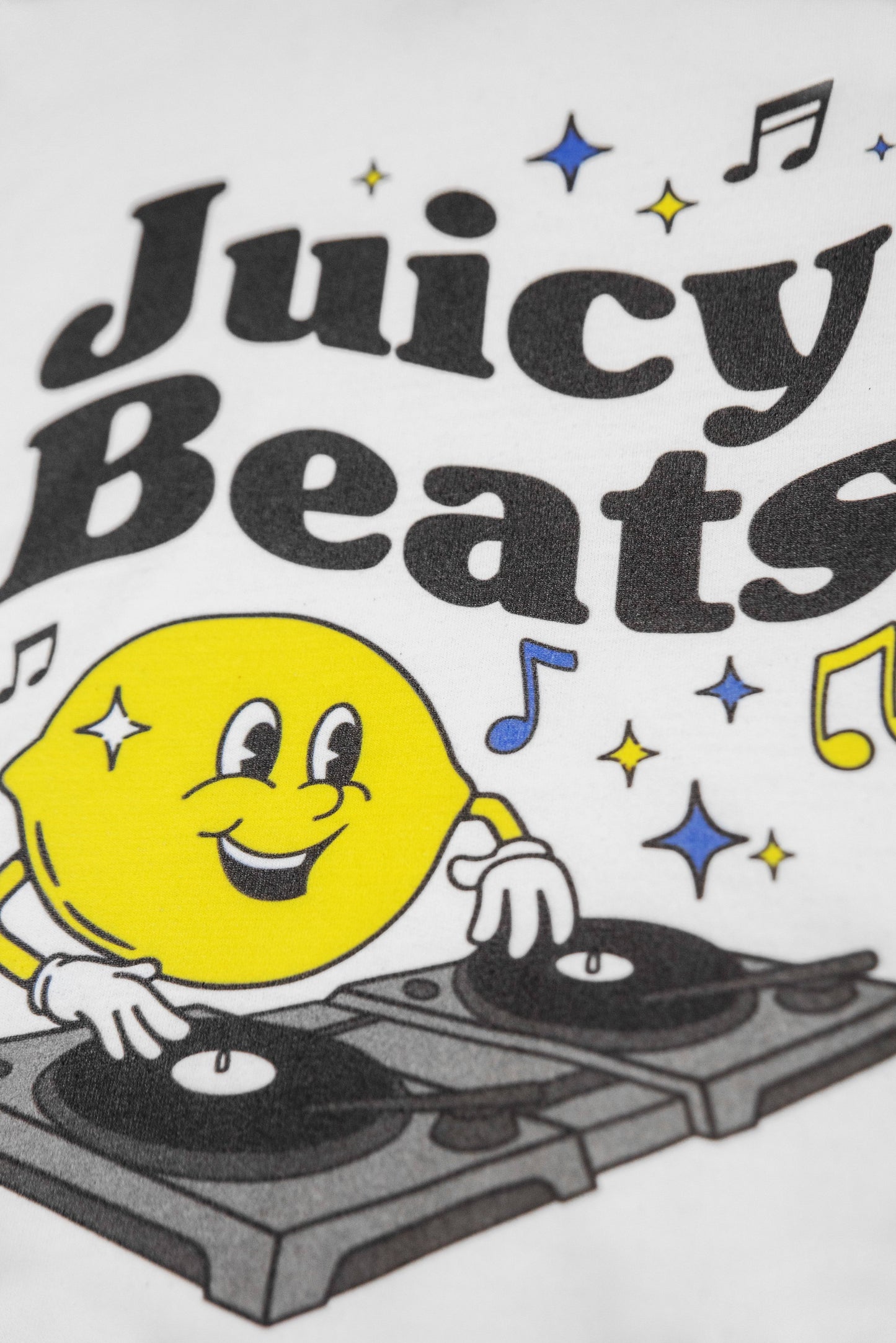 Detailed view of Juicy Beats graphic on white hoodie with vibrant lemon DJ and bold typography, great for fans of playful and bold outerwear.