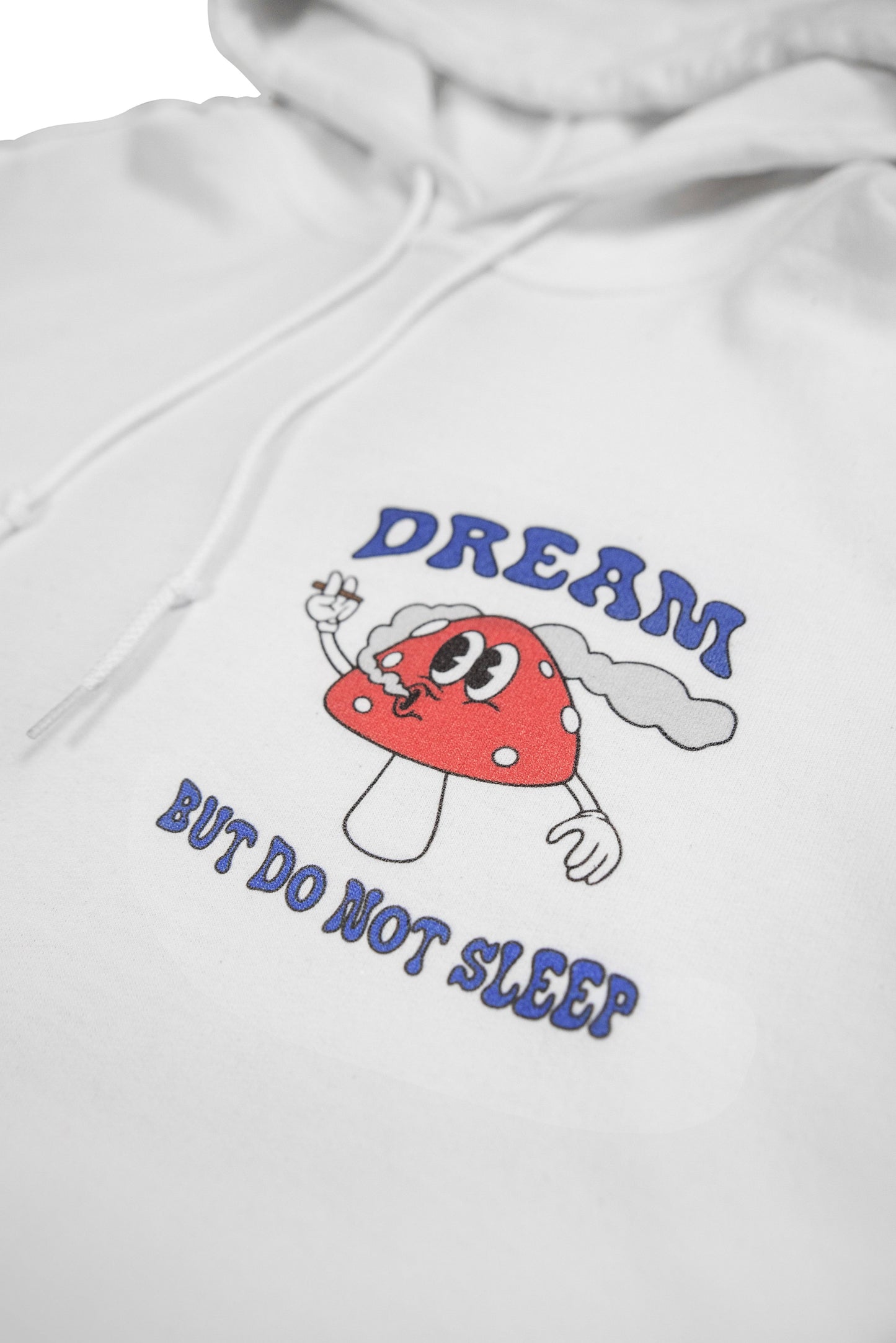 Zoomed-in detail of front mushroom print and slogan on white hoodie. Soft cotton fabric with bold y2k-inspired streetwear design.