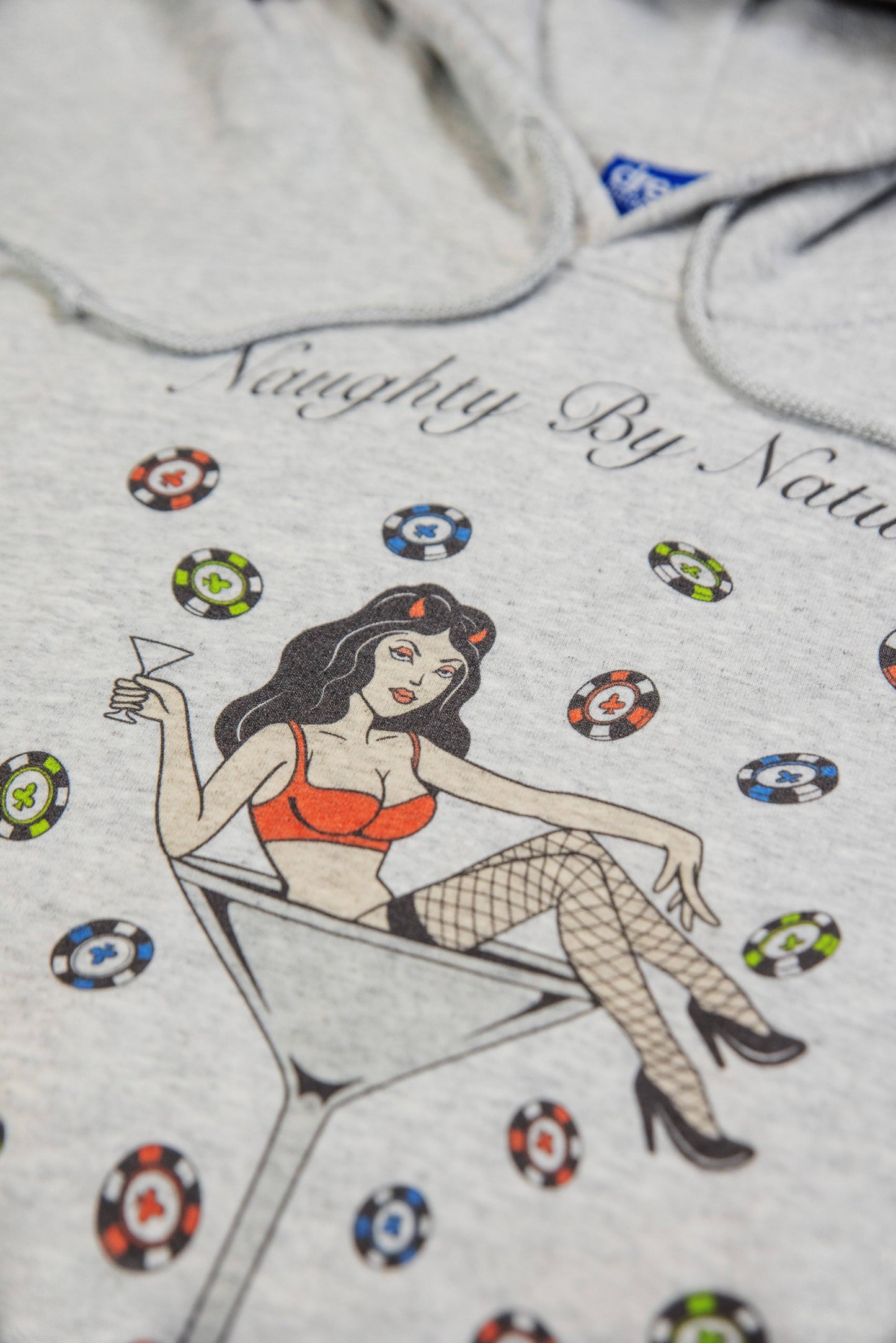 Detailed view of the Naughty By Nature print on Ash Grey Hoodie highlighting the vibrant colors and playful casino-themed design.