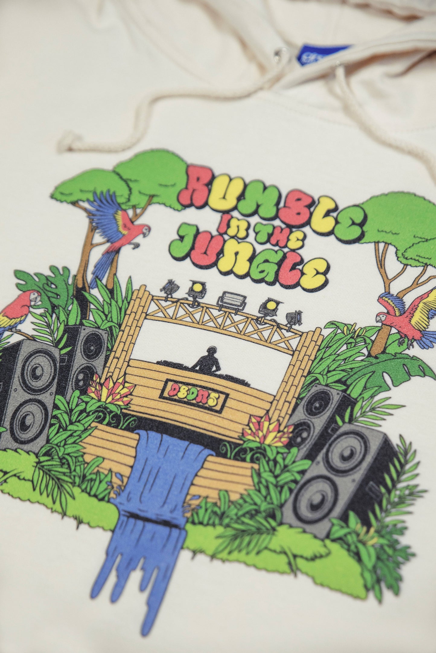 Detailed view of Rumble In The Jungle print on Vanilla Cream Hoodie, highlighting vibrant jungle elements and bold streetwear design.