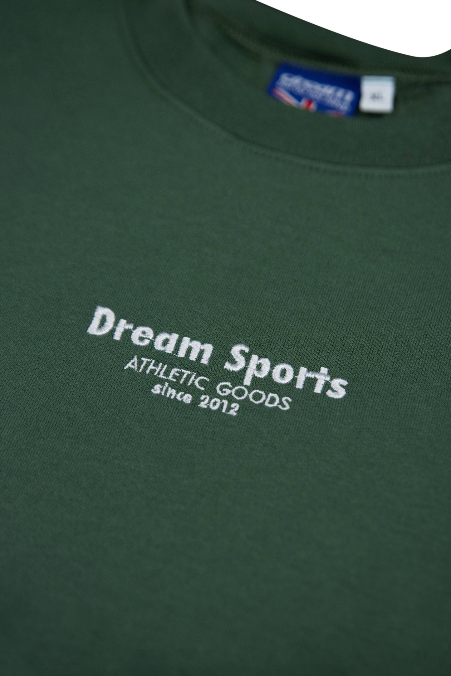 Detailed view of embroidered Dream Sports logo on Military Green Sweatshirt, highlighting athletic branding and soft cotton texture.