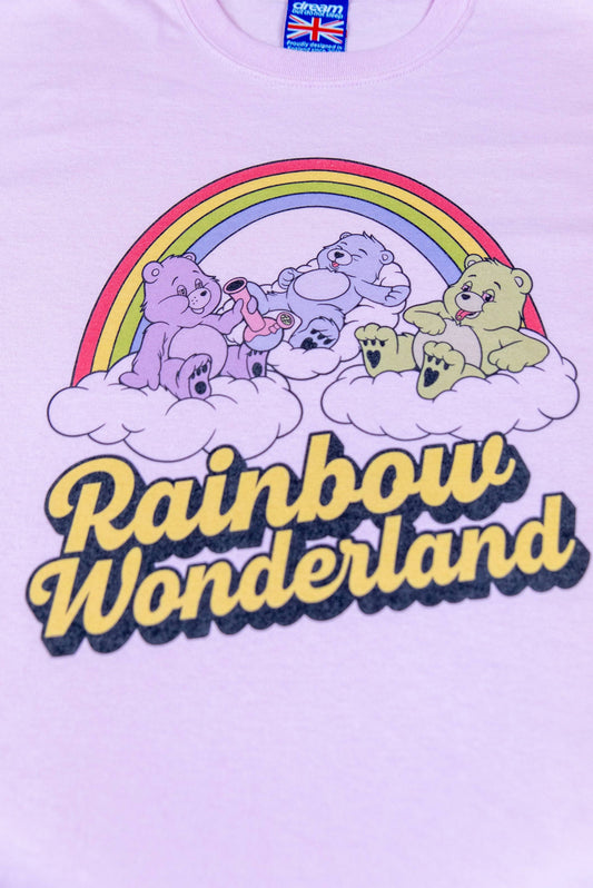 Close-up of light pink cotton t-shirt with vibrant DTG 'Rainbow Wonderland' print showing colorful cartoon bears and rainbow design.