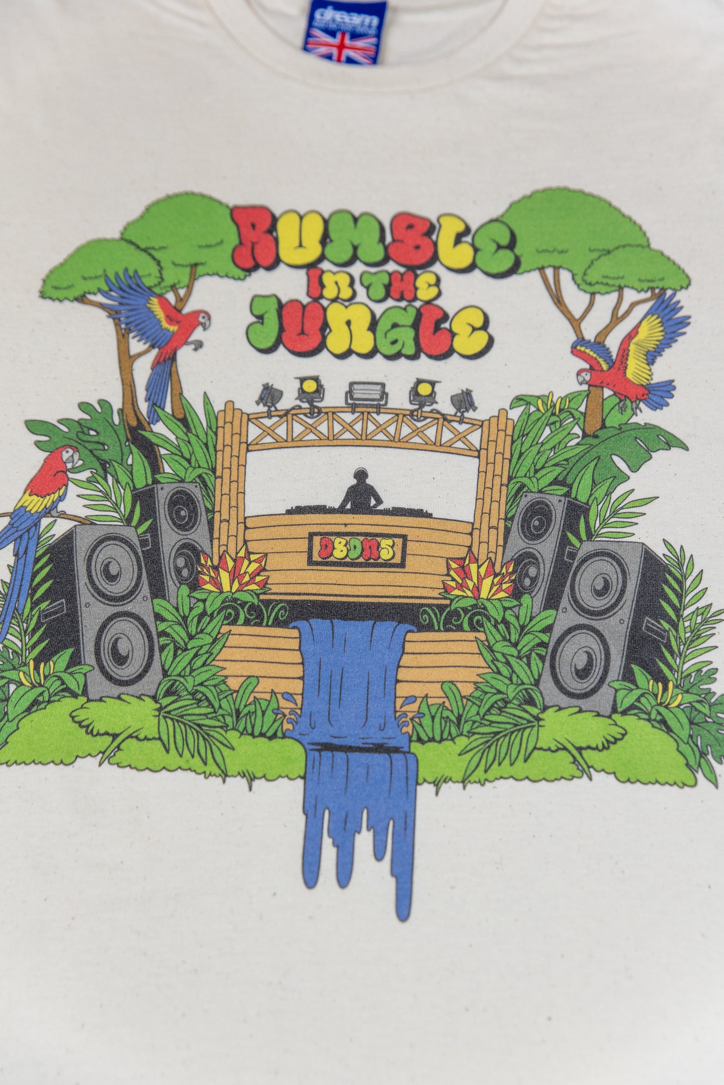 Close-up of Rumble In The Jungle print on unisex cotton t-shirt with colorful DTG artwork, DJ booth, parrots, and jungle scenery.