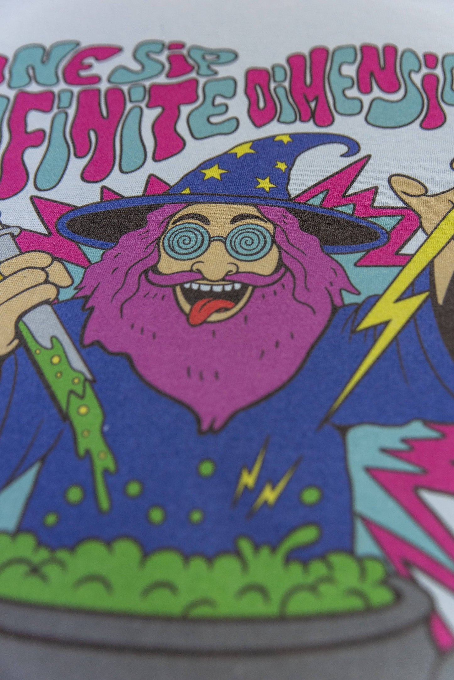 Detailed view of wizard's face and cauldron on Light Blue T-Shirt Unisex with Tripping Wizard print, showcasing vivid DTG print quality.