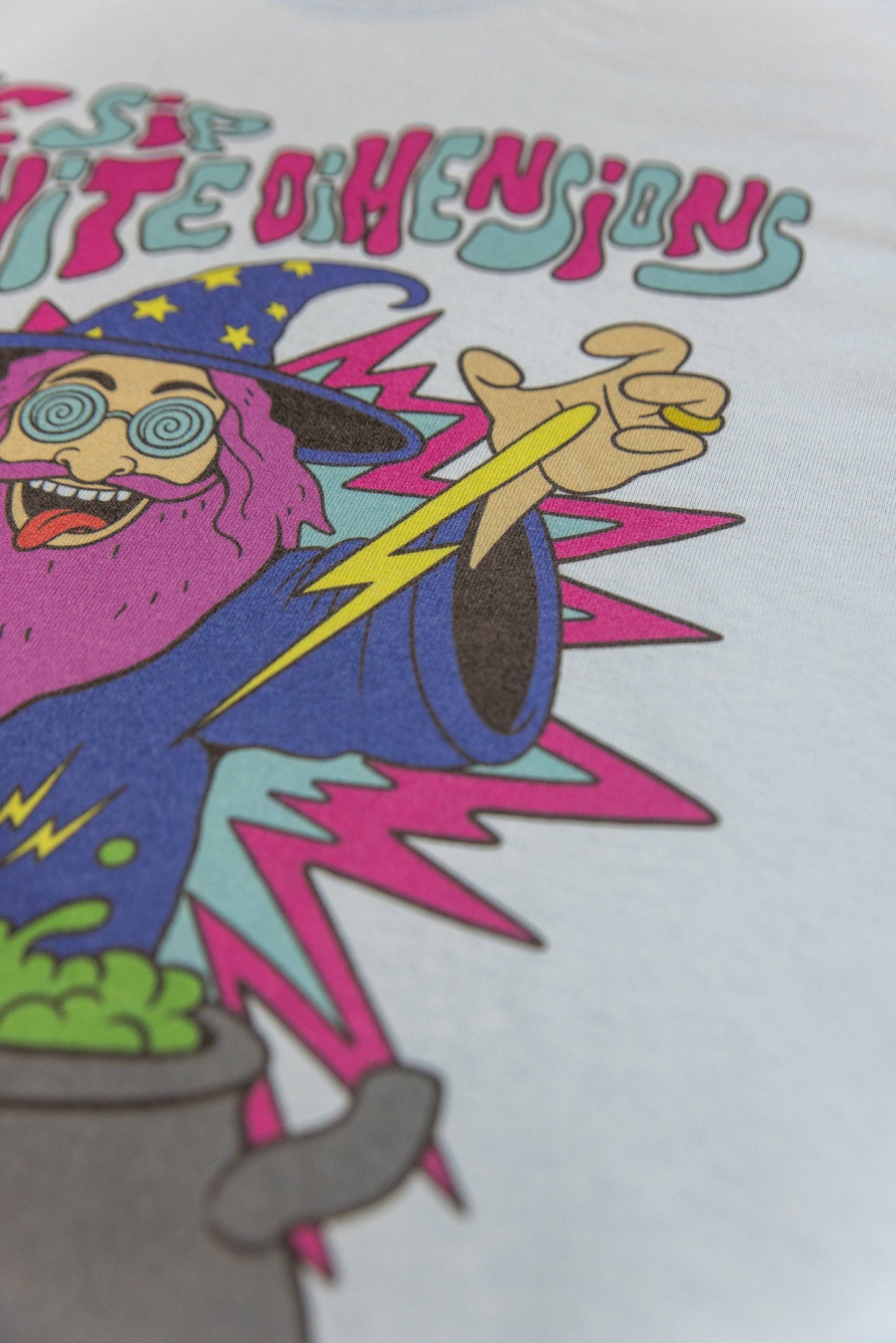 Zoomed-in view of wizard's lightning hand on Light Blue T-Shirt Unisex with Tripping Wizard print, emphasizing bold graphic details.