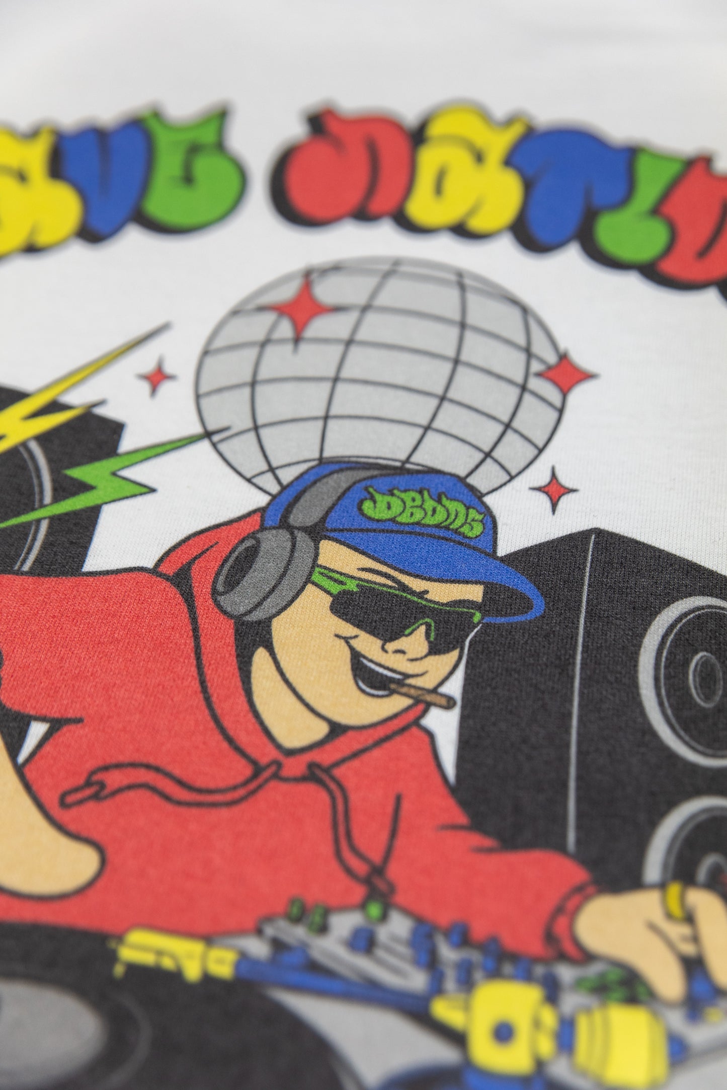 Zoomed-in image of cartoon DJ with cap and sunglasses on Rave Nation T-shirt. Features colorful design and crisp print quality.