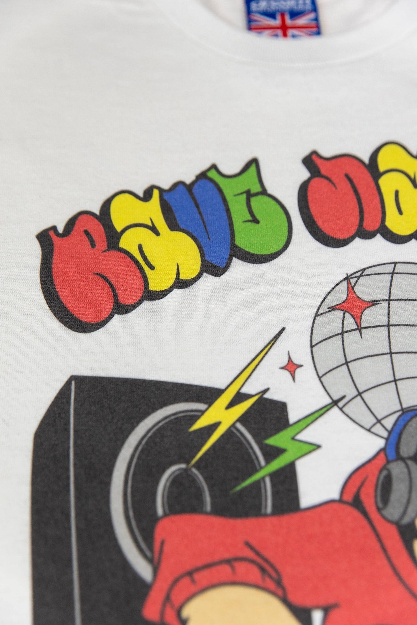 Top section of Rave Nation T-shirt showing bold rainbow text and speaker graphic. Made from 100% soft cotton with UK label.