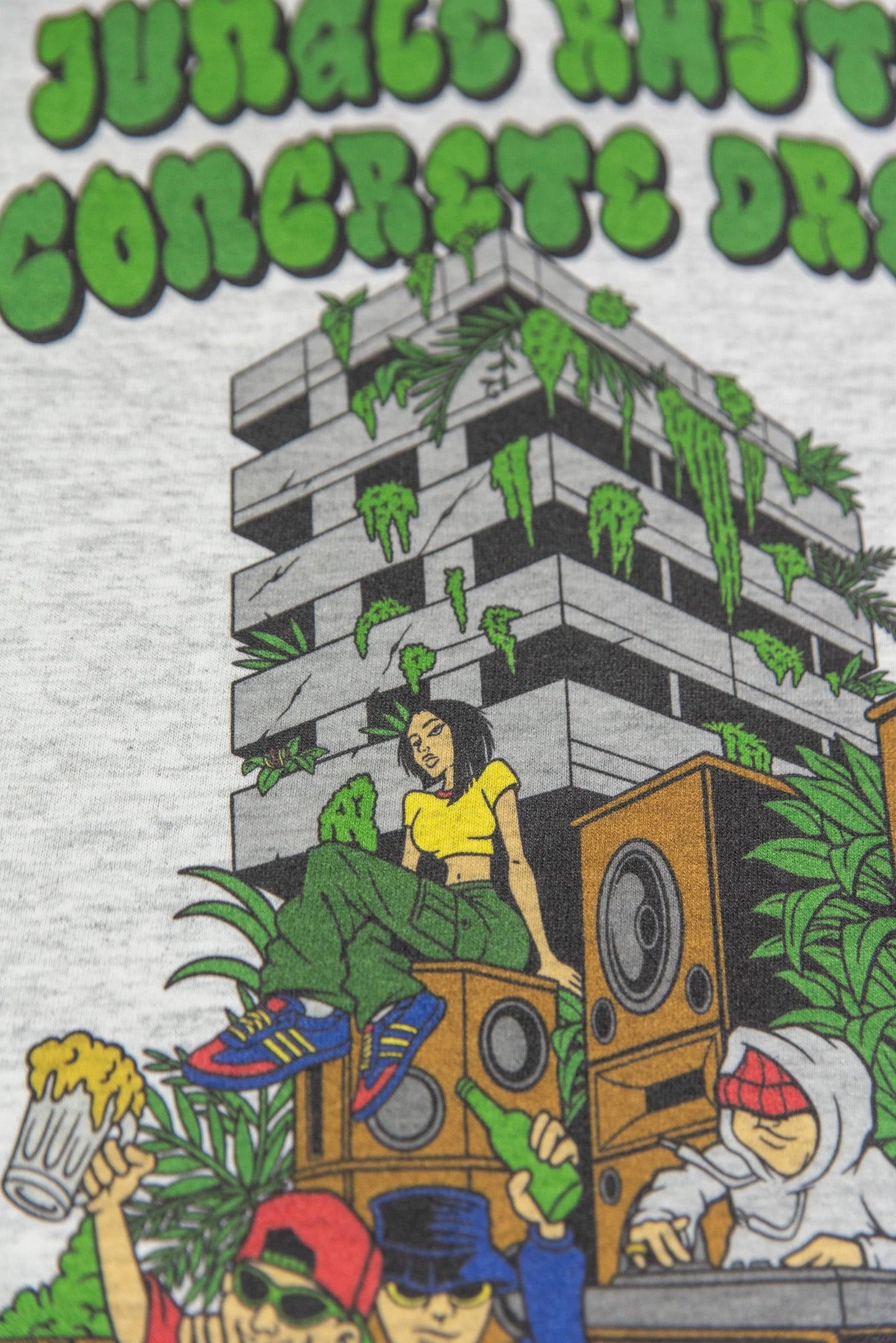 Upper section of Jungle Rhythms print on Ash Grey T-Shirt showing woman on rooftop with greenery and graffiti-style text.