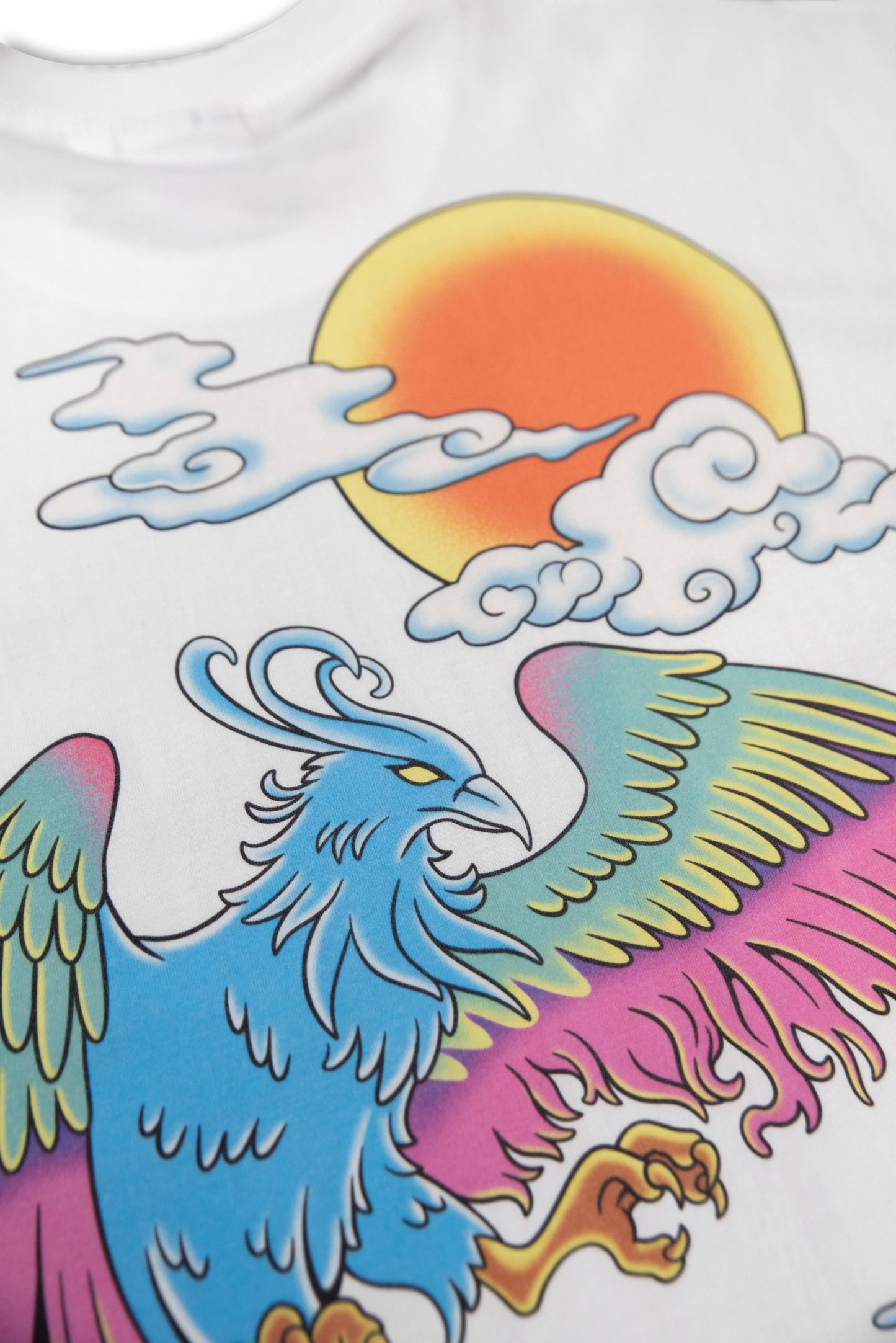 Close-up of the White Phoenix T-Shirt's DTG print showing detailed phoenix wings and a vivid orange sun. High-quality cotton fabric enhances color vibrancy.