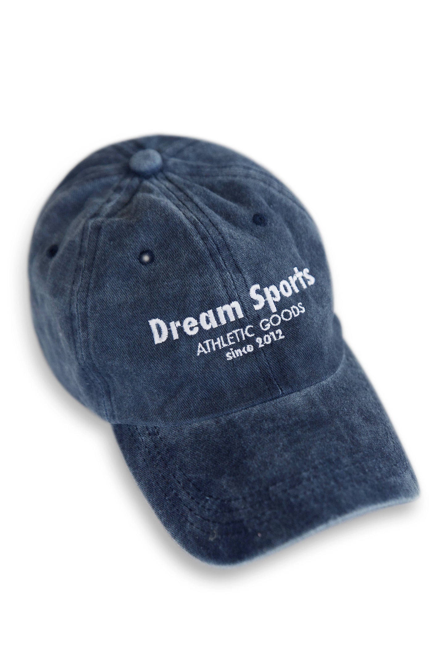 Vintage navy sports cap with white 'Dream Sports Athletic Goods' embroidery, low-profile cotton design with curved brim and adjustable strap.