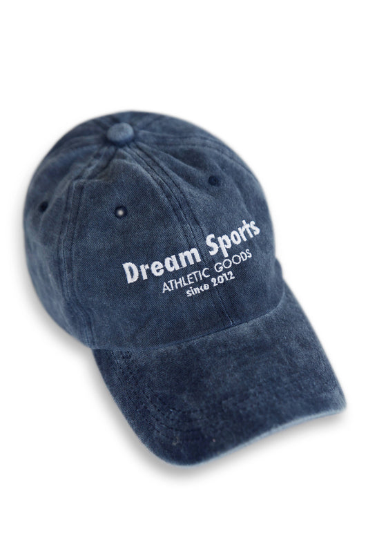 Vintage navy sports cap with white 'Dream Sports Athletic Goods' embroidery, low-profile cotton design with curved brim and adjustable strap.